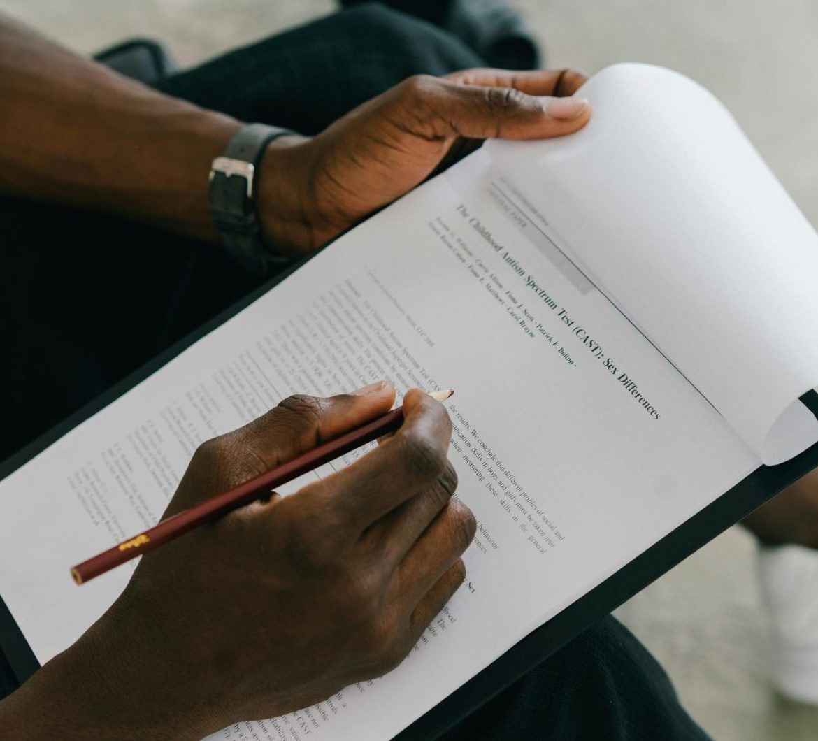 Close-up of a person writing on a psychological assessment form with a pencil.